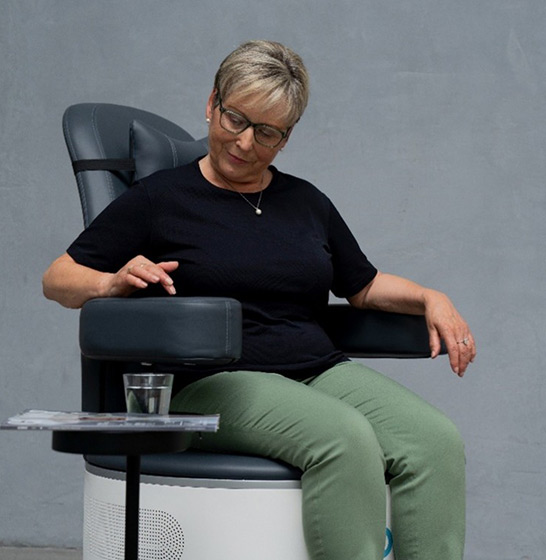 Patientin sitzt auf Therapiestuhl