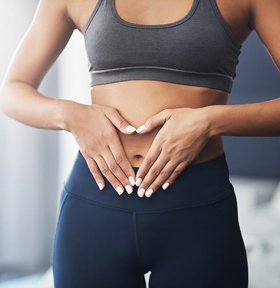 Patientin greif sich auf Bauch wegen Schmerzen